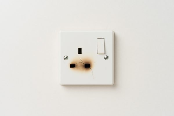 Damaged electrical domestic power socket with cracks and burn marks